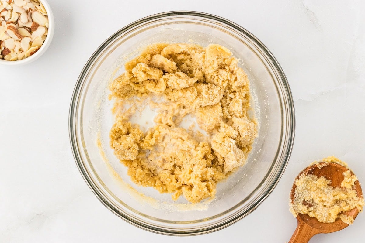 Milk being added to almond flour dough mixture in bowl