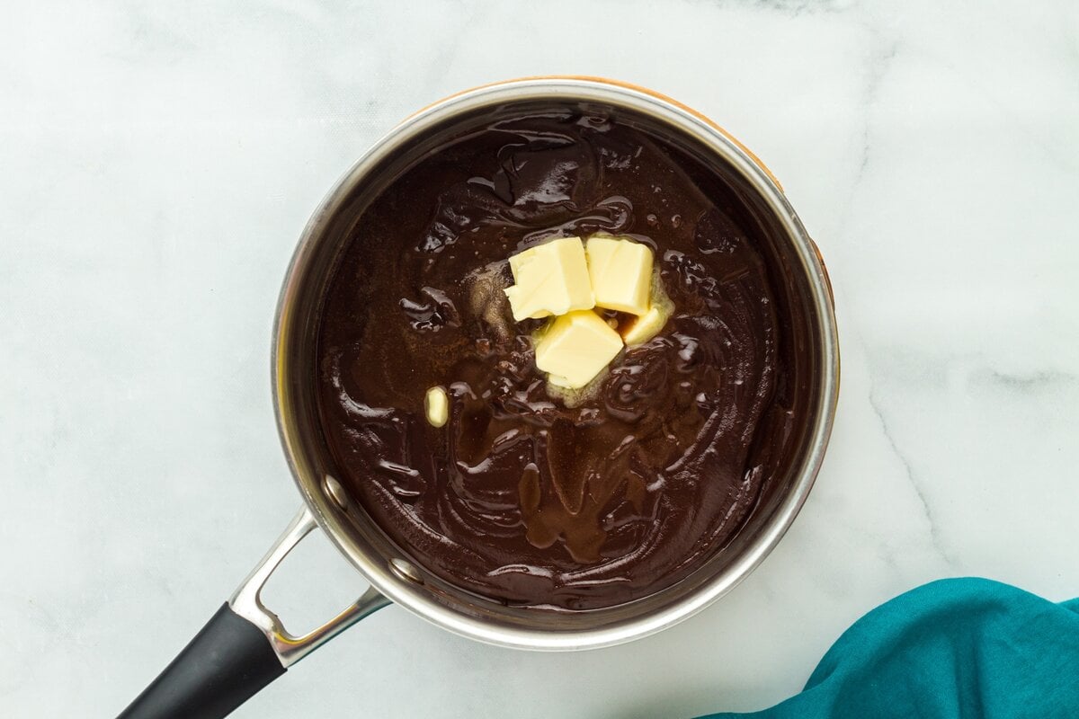Butter added to hot chocolate custard in a saucepan to finish the filling.