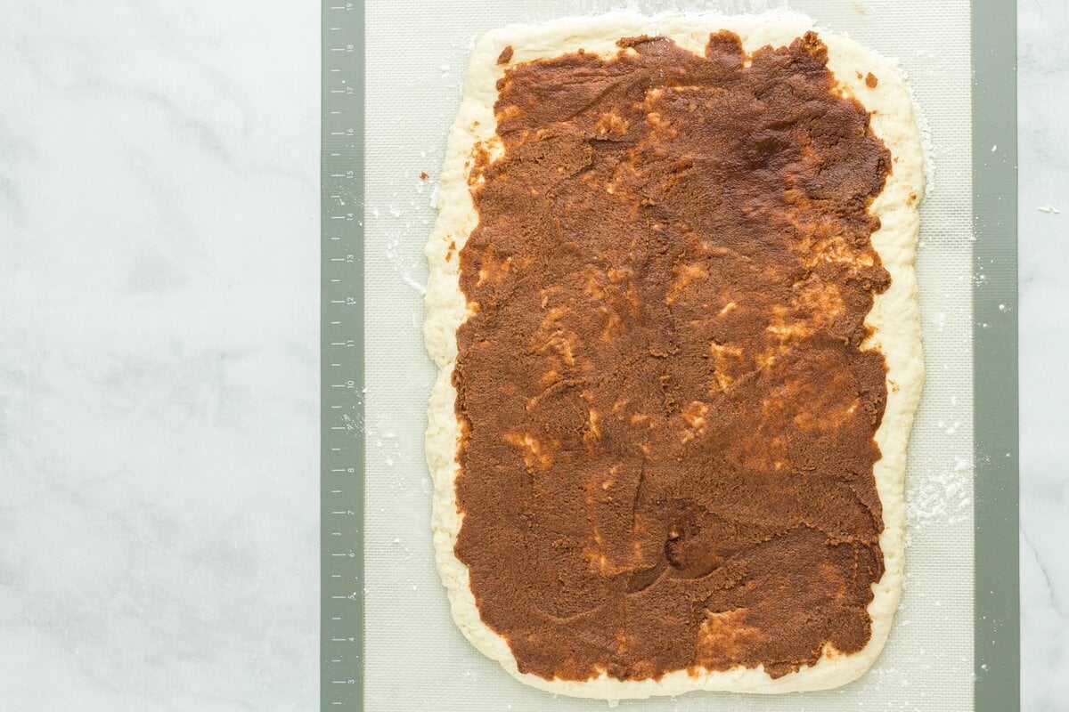 Cinnamon sugar filling evenly spread over rolled gluten free dough rectangle.