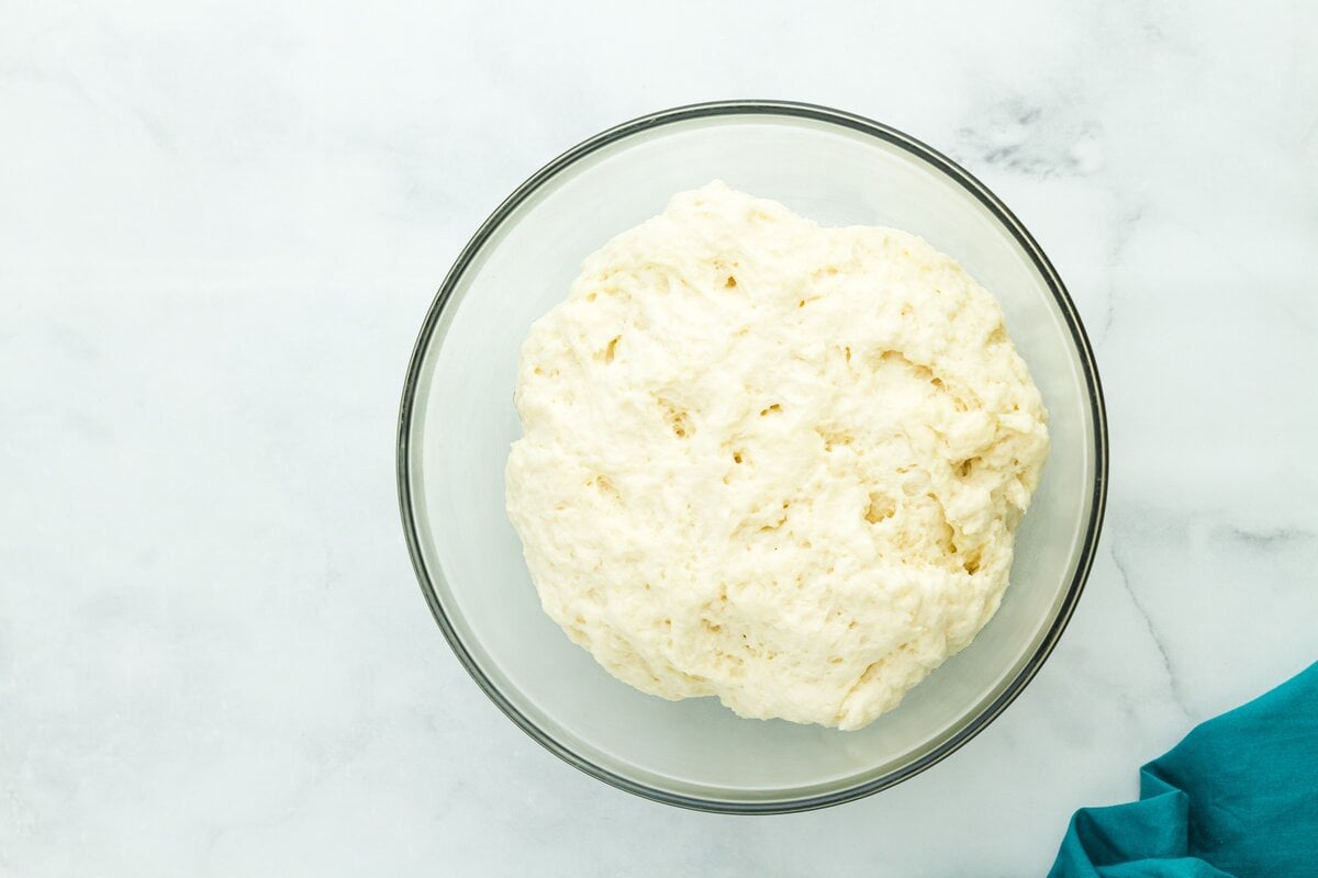 Smooth, fully mixed gluten free dough in a bowl with soft, stretchy texture.