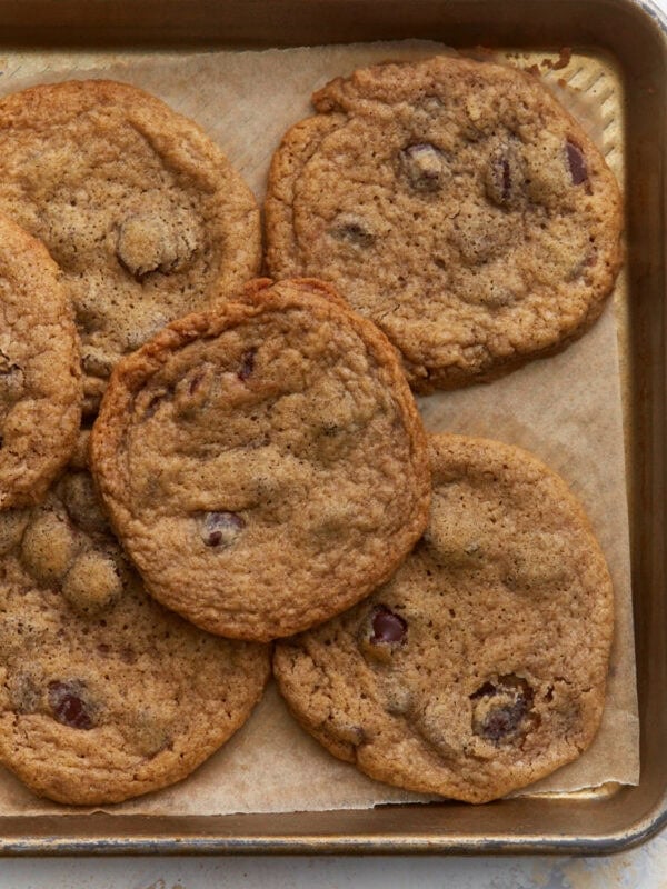 Baked buckwheat chocolate chip cookies cooling on a parchment lined baking sheet with crisp edges and soft centers