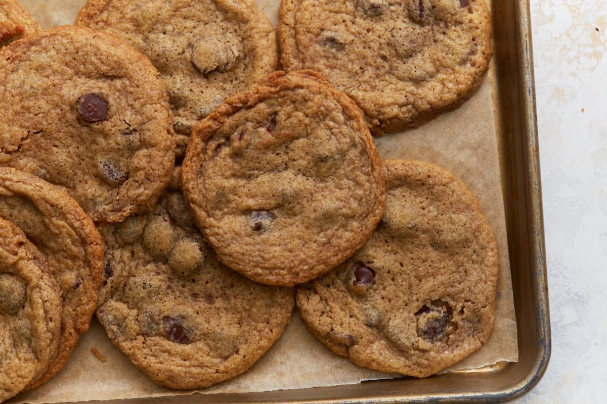 Close up of buckwheat chocolate chip cookies on a baking sheet highlighting the texture and melted chocolate chips