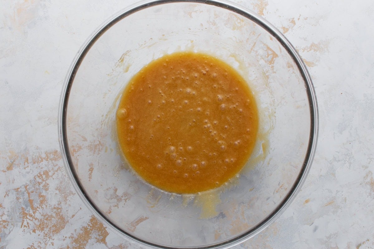 Egg and vanilla whisked into the melted butter and sugar mixture until smooth and glossy