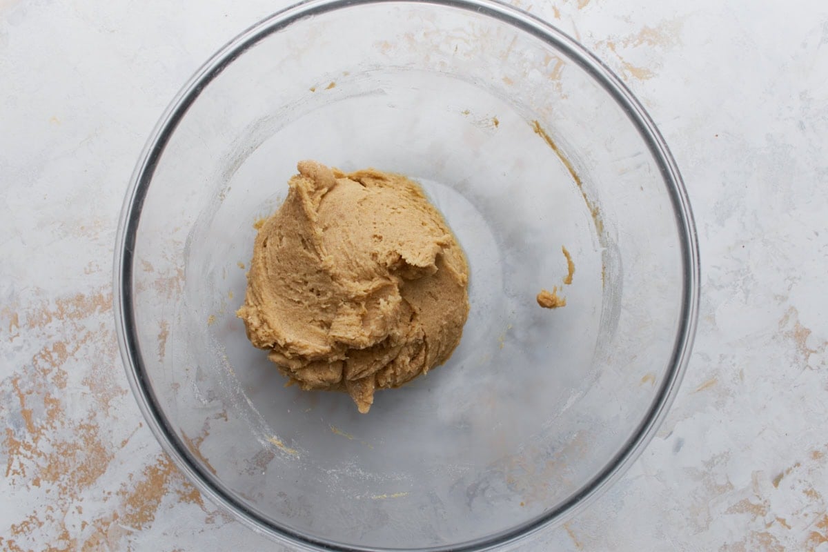 Buckwheat cookie dough fully mixed and formed into a soft ball inside a glass bowl