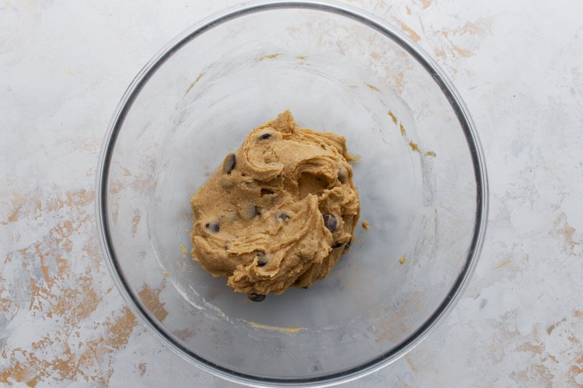 Chocolate chips folded into thick buckwheat cookie dough