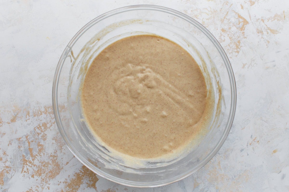 Buckwheat waffle batter mixed in a glass bowl with slightly thick, speckled texture