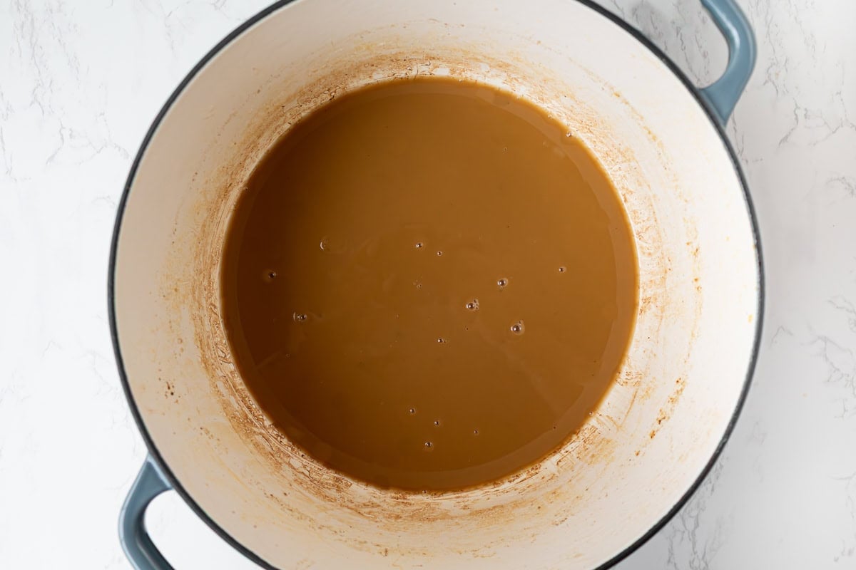 Gluten free roux cooked to a smooth dark peanut butter color inside a Dutch oven.