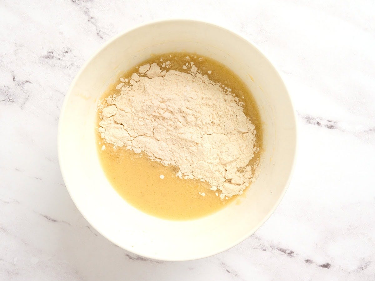 Dry coconut flour mixture added to wet ingredients in a bowl to make pancake batter