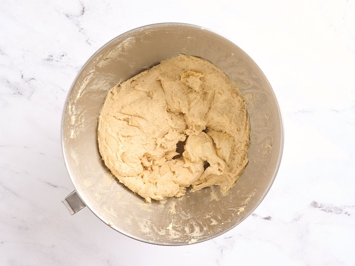 Freshly mixed gluten free challah bread dough resting in a stand mixer bowl.