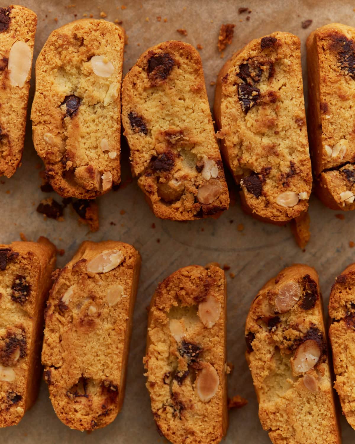 Close-up of sliced almond flour biscotti with chocolate chips and sliced almonds on parchment paper