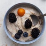 Dairy-free fruit dip topped with blackberries, blueberries, and a golden berry in a small bowl.
