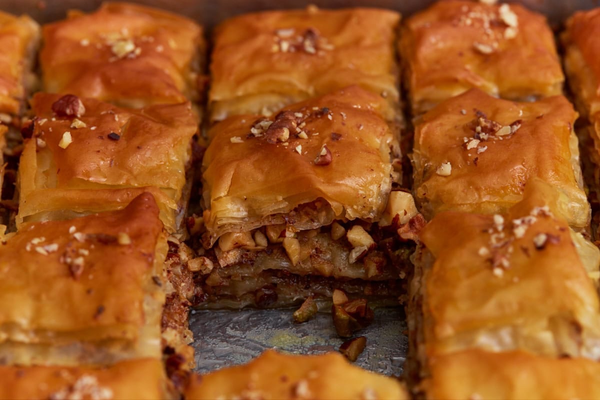 Close-up of gluten-free baklava showing flaky phyllo layers and chopped nut filling.