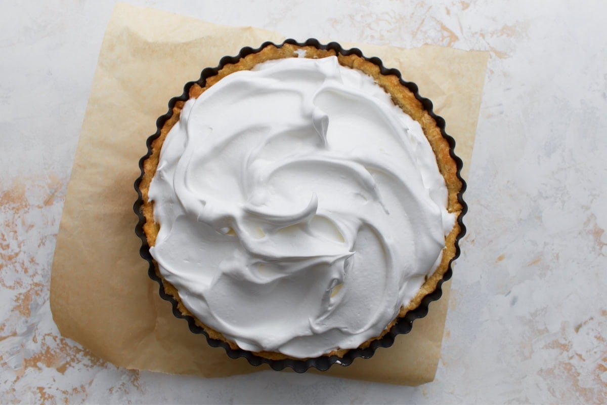 Fresh meringue spread over hot lemon filling in a gluten-free pie crust