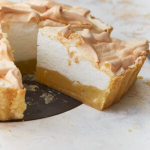 Slice of gluten-free lemon meringue pie showing layers of lemon filling and fluffy toasted meringue