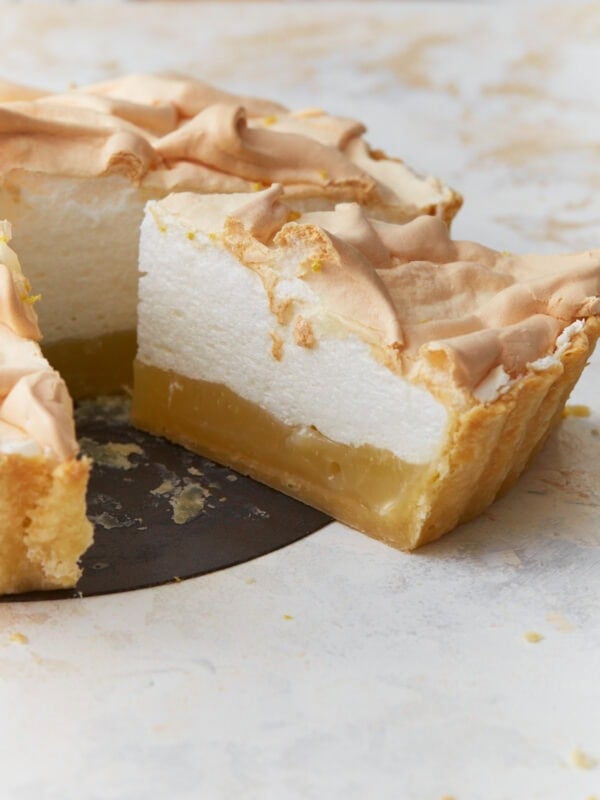 Slice of gluten-free lemon meringue pie showing layers of lemon filling and fluffy toasted meringue