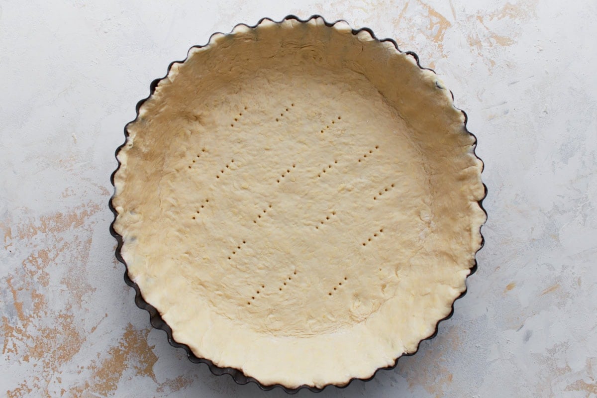 Gluten-free pie crust pressed into a tart pan and docked with a fork