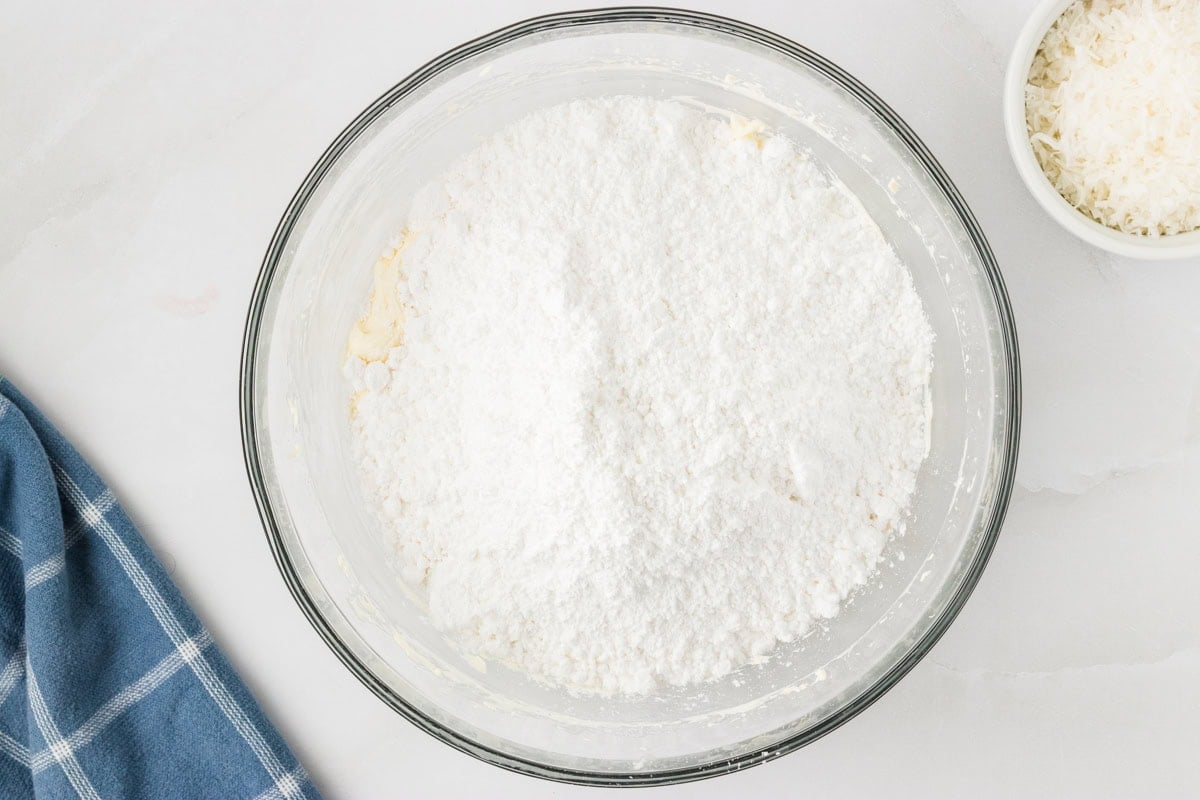 mixing ingredients to make cream cheese frosting for gluten free coconut cake