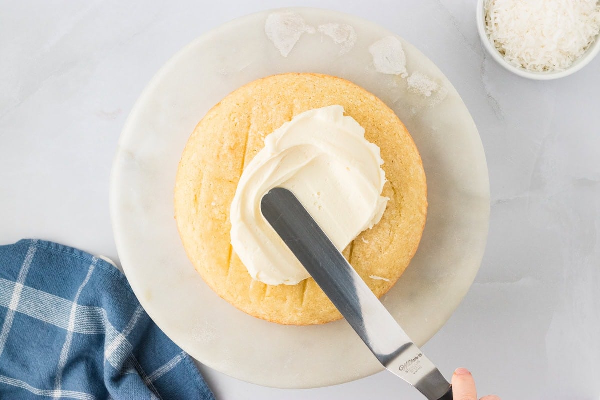 frosting the cream cheese on gluten free coconut cake