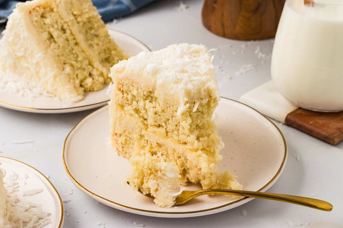 sliced gluten-free coconut cake on a plate with a fork taking a bite