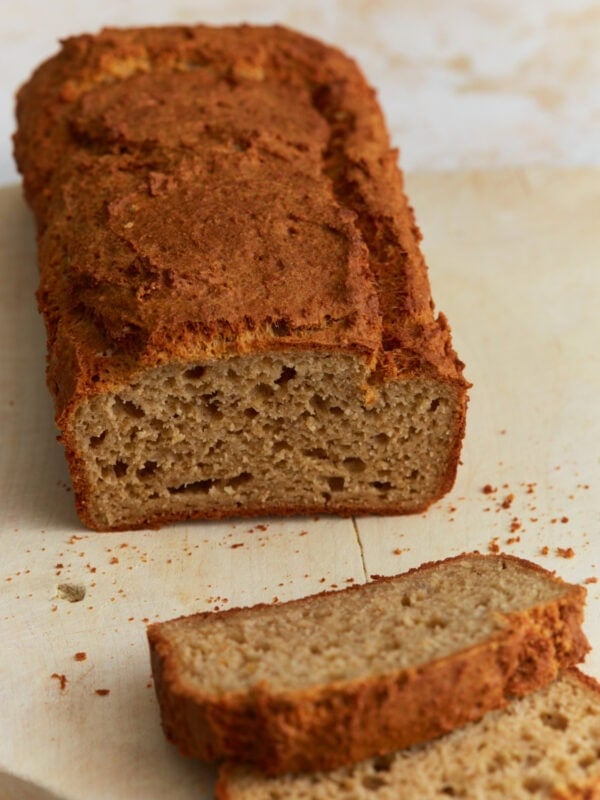 Sliced oat flour bread loaf showing soft, dense crumb and golden brown crust on a wooden cutting board