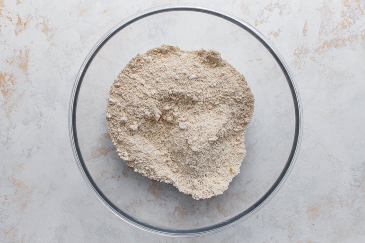 Homemade oat flour made from blended oats in a glass mixing bowl