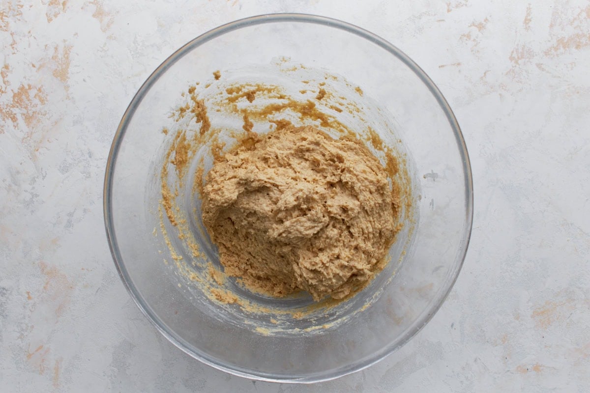 Thick oat flour bread batter in a glass bowl showing dense, sticky texture before baking