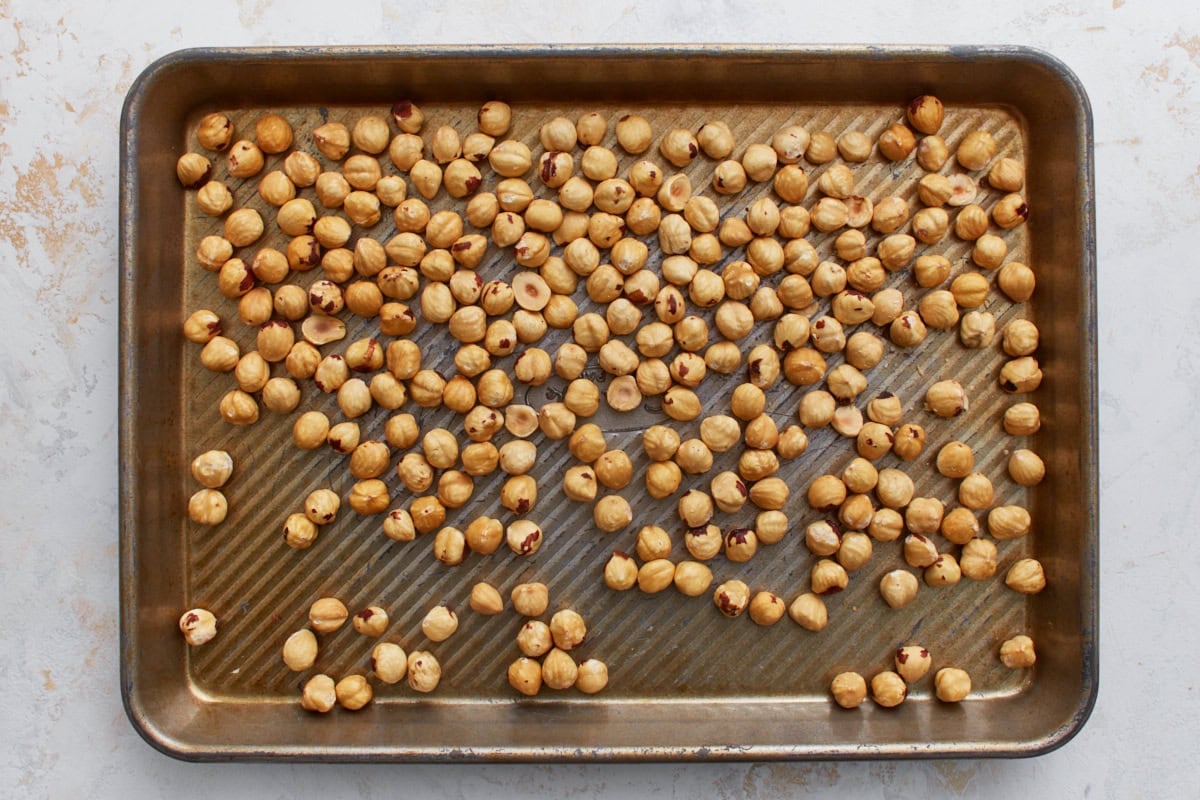 Blanched hazelnuts spread on a baking sheet ready for roasting to make vegan Nutella