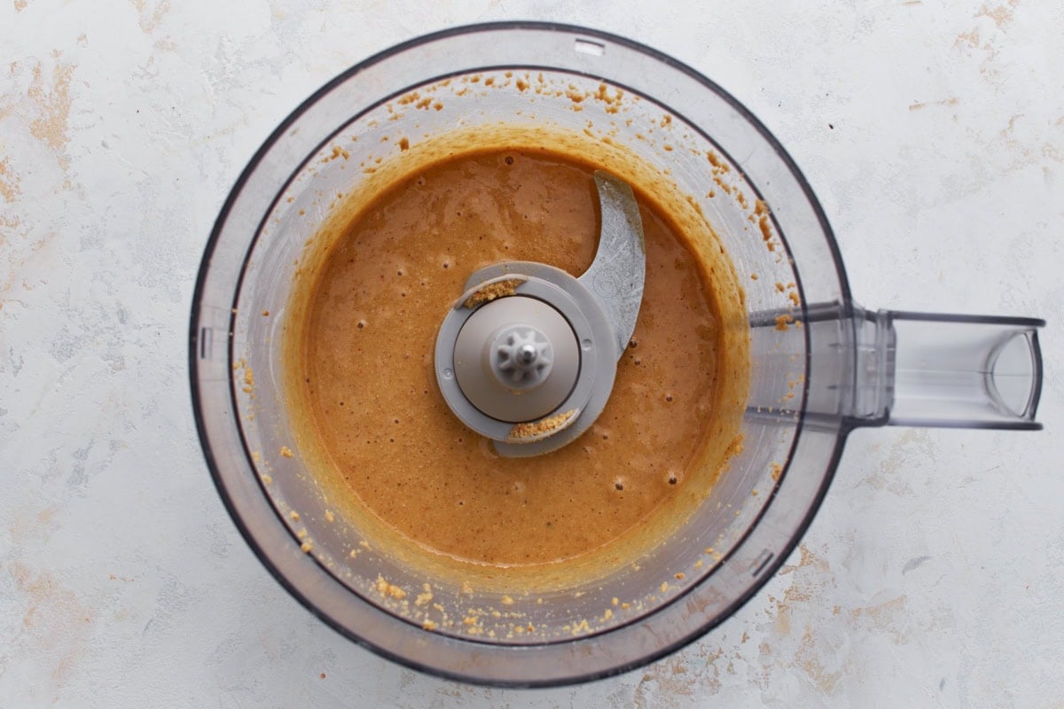 Hazelnuts blended in a food processor starting to form a thick, creamy nut butter