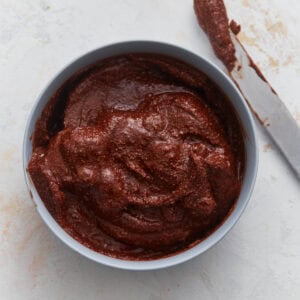 Creamy vegan Nutella in a bowl with a knife, showing thick, rich chocolate hazelnut spread texture