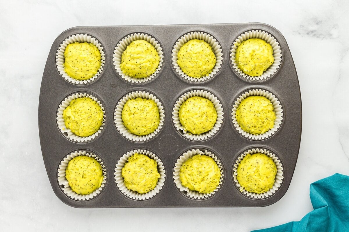 Gluten-free lemon poppy seed muffin batter scooped evenly into lined muffin tin before baking