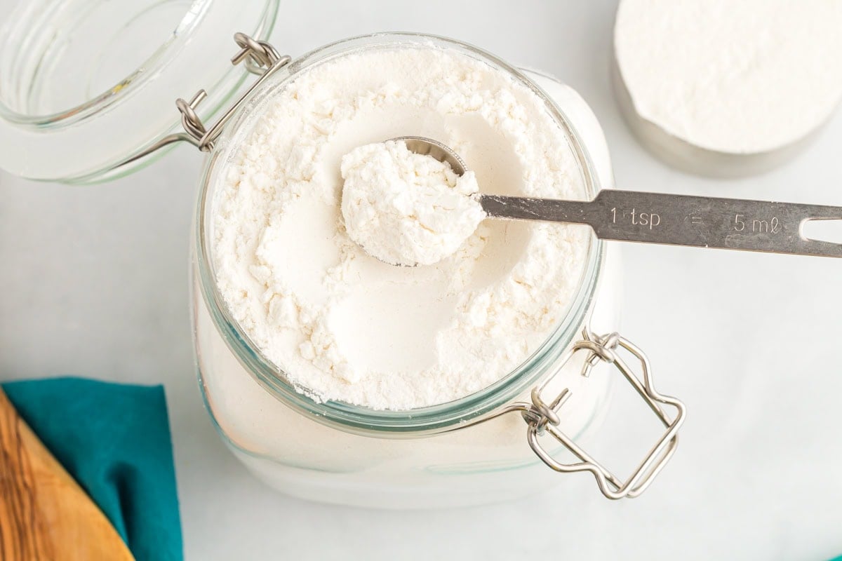 Close up of homemade gluten free flour blend with a teaspoon scoop showing texture