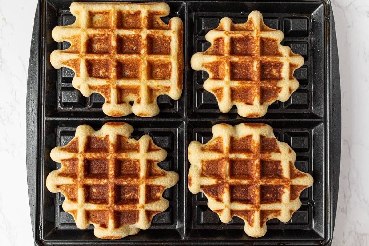 Gluten-free coconut flour waffles cooking in a waffle iron until golden brown and crisp