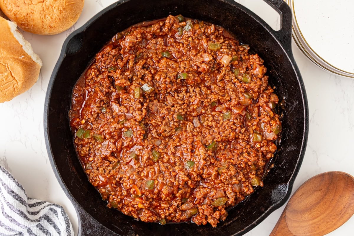 Sloppy joe mixture simmering in a cast iron skillet until thick and saucy