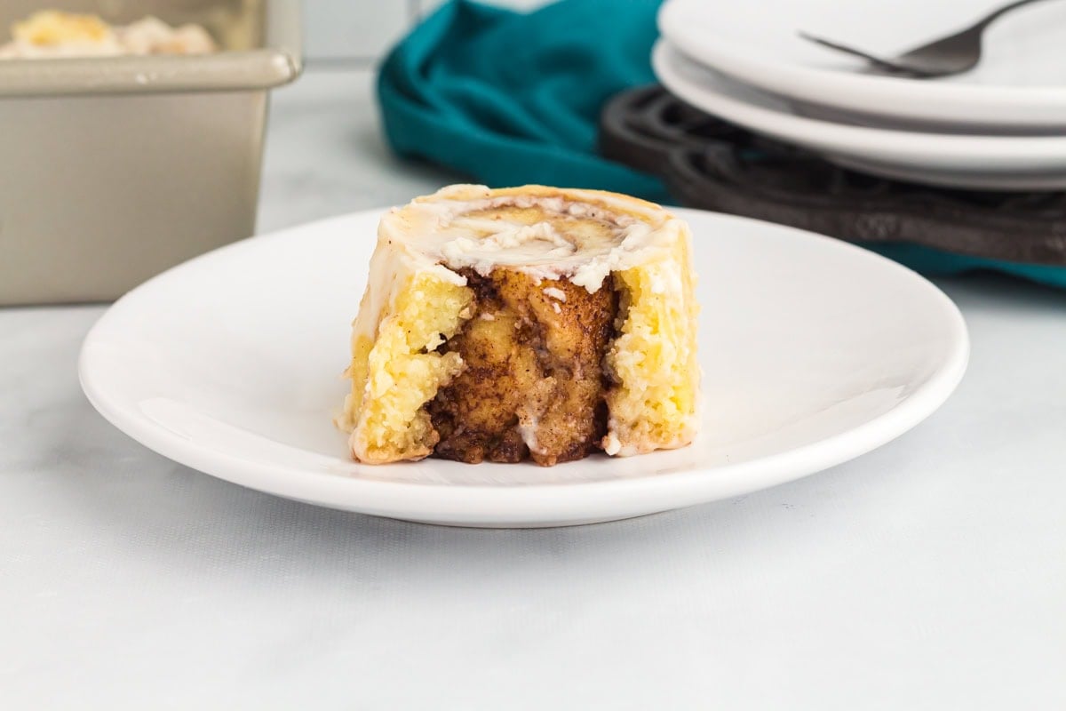 Single keto cinnamon roll on a plate showing soft, cinnamon swirl center