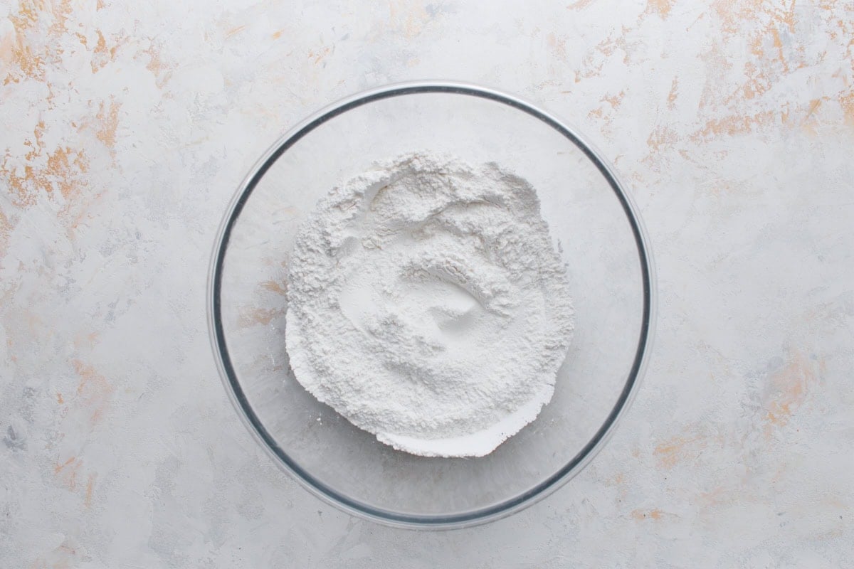 Glutinous rice flour mixture for gluten-free mochi donuts in a glass mixing bowl
