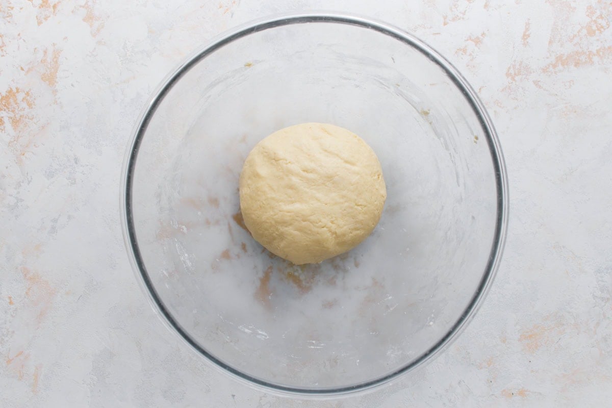 Soft mochi donut dough formed into a smooth ball in a glass bowl