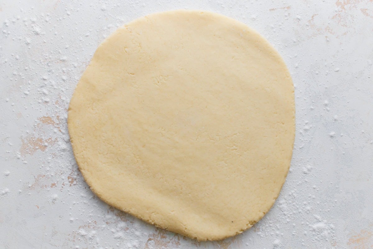 Rolled-out gluten-free mochi donut dough on a lightly floured surface