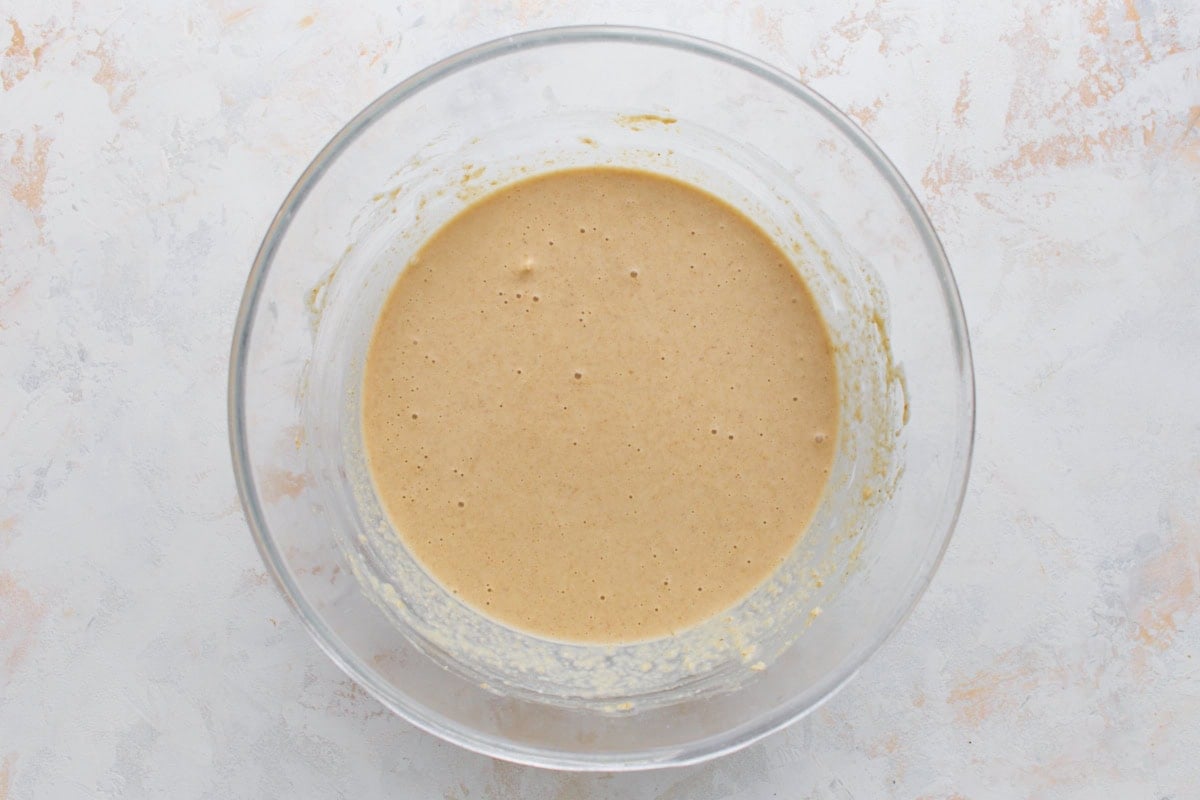 Oat flour waffle batter mixed until smooth in a glass bowl.