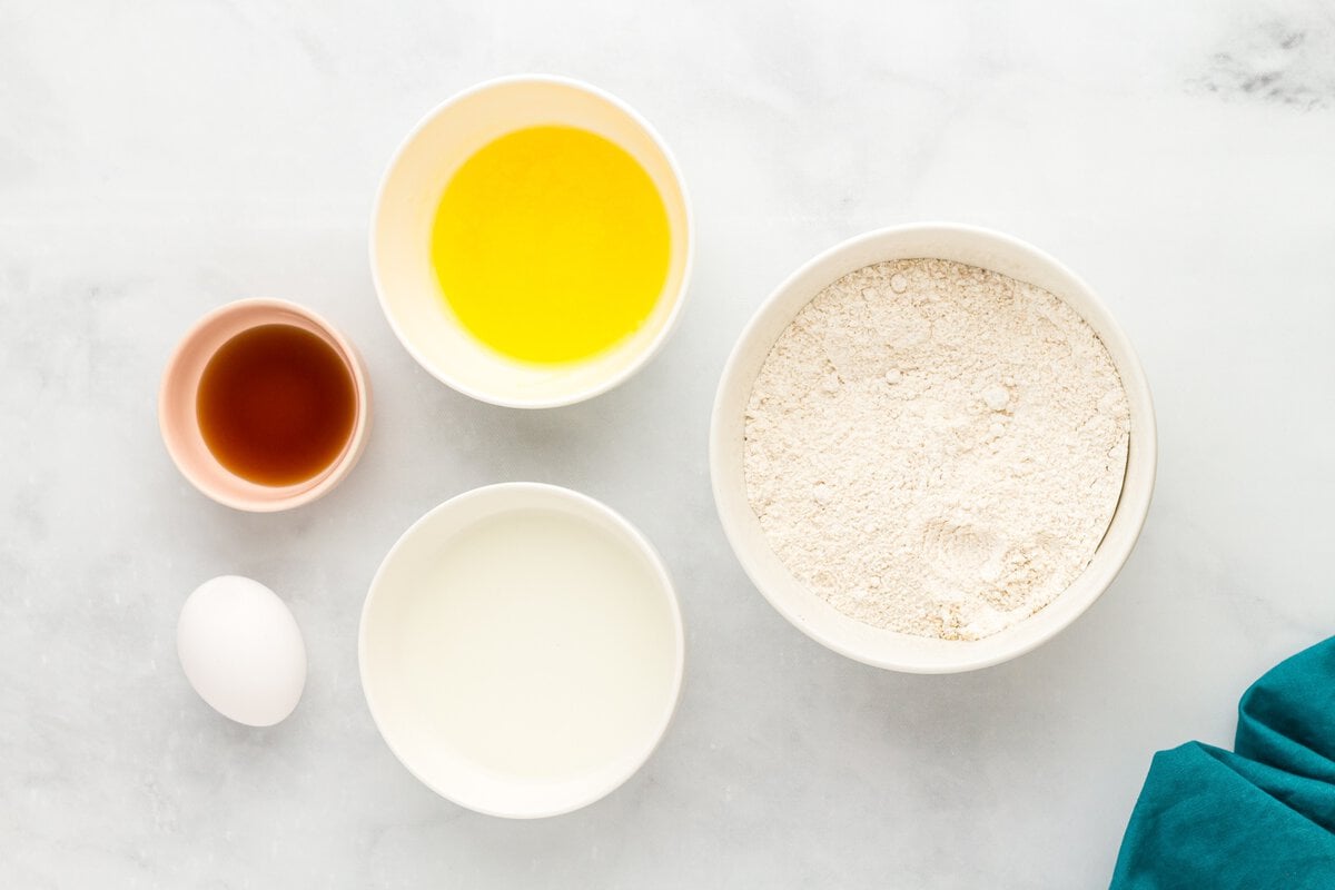 Ingredients for gluten-free vanilla cake donuts including gluten-free flour, milk, egg, melted butter, and vanilla extract.