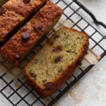Overhead view of sliced almond flour zucchini bread with chocolate chips on a black wire cooling rack