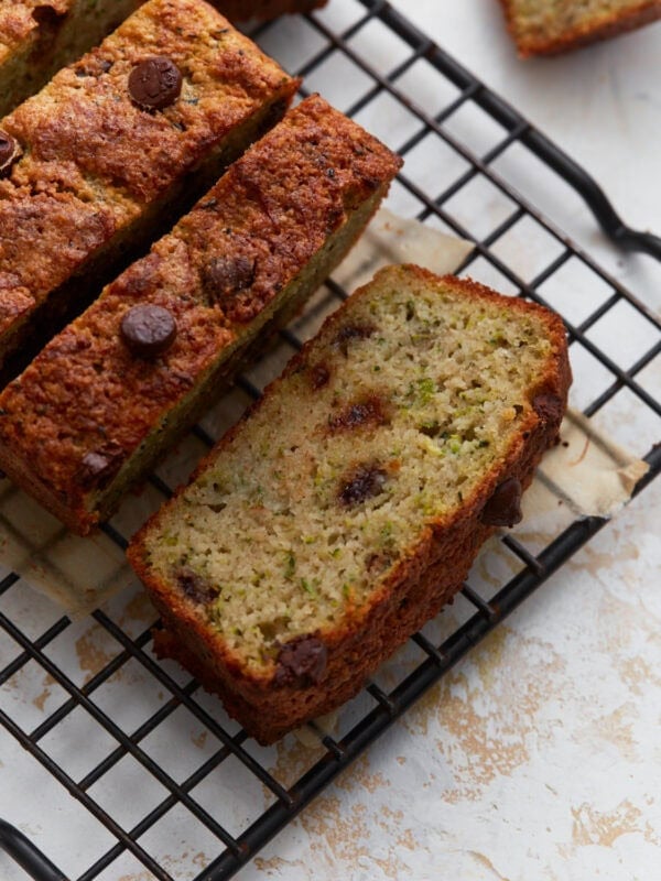 Overhead view of sliced almond flour zucchini bread with chocolate chips on a black wire cooling rack