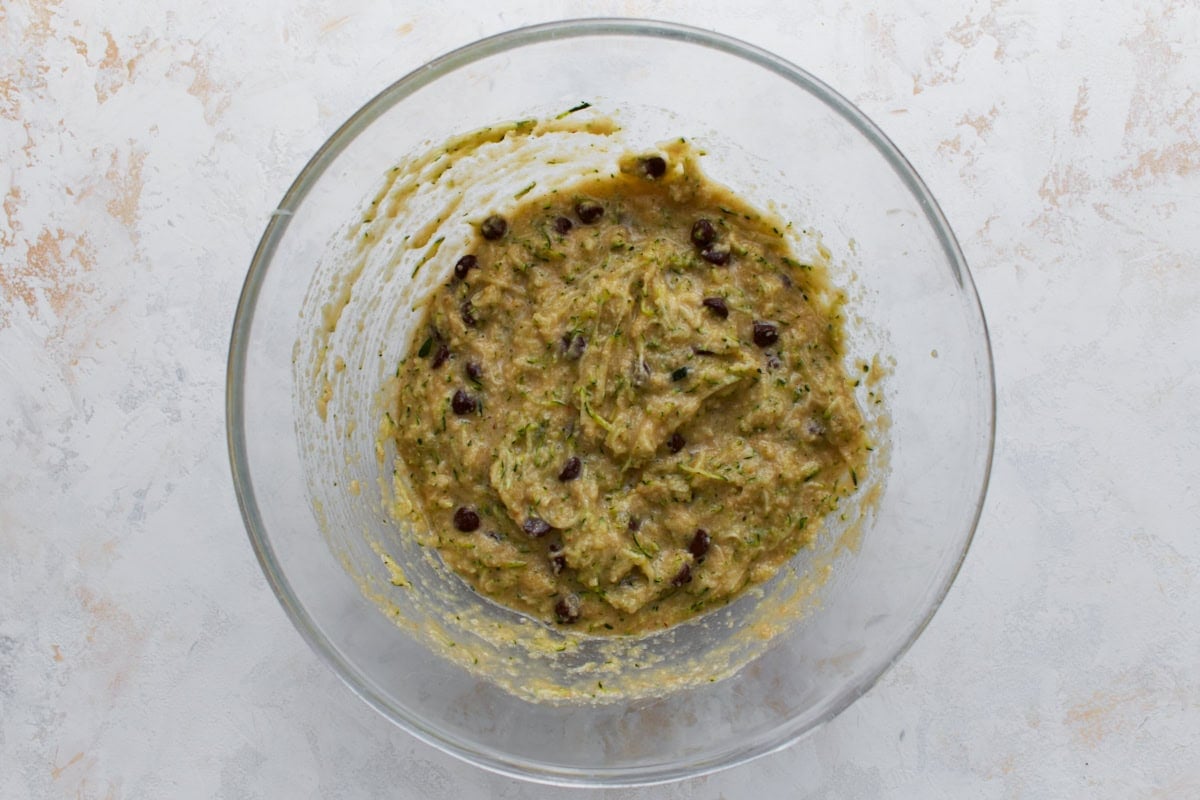 Overhead view of almond flour zucchini bread batter with grated zucchini and chocolate chips folded in