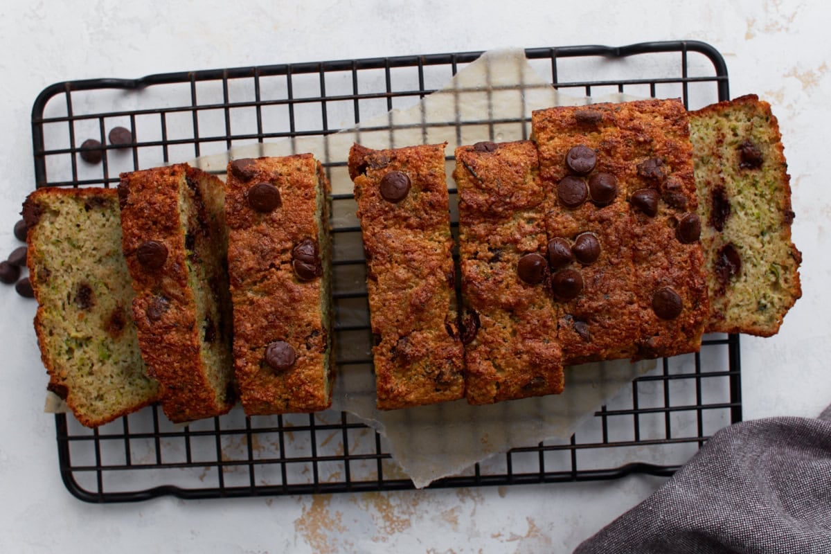Overhead view of almond flour zucchini bread sliced into pieces on a black wire cooling rack