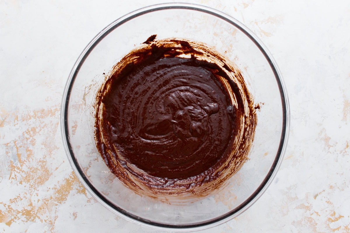 Melted chocolate folded into the whipped egg mixture, forming a smooth, glossy batter.