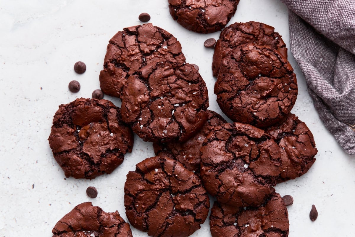 Close-up of stacked flourless chocolate cookies showing their crinkled, crackled tops and fudgy edges.