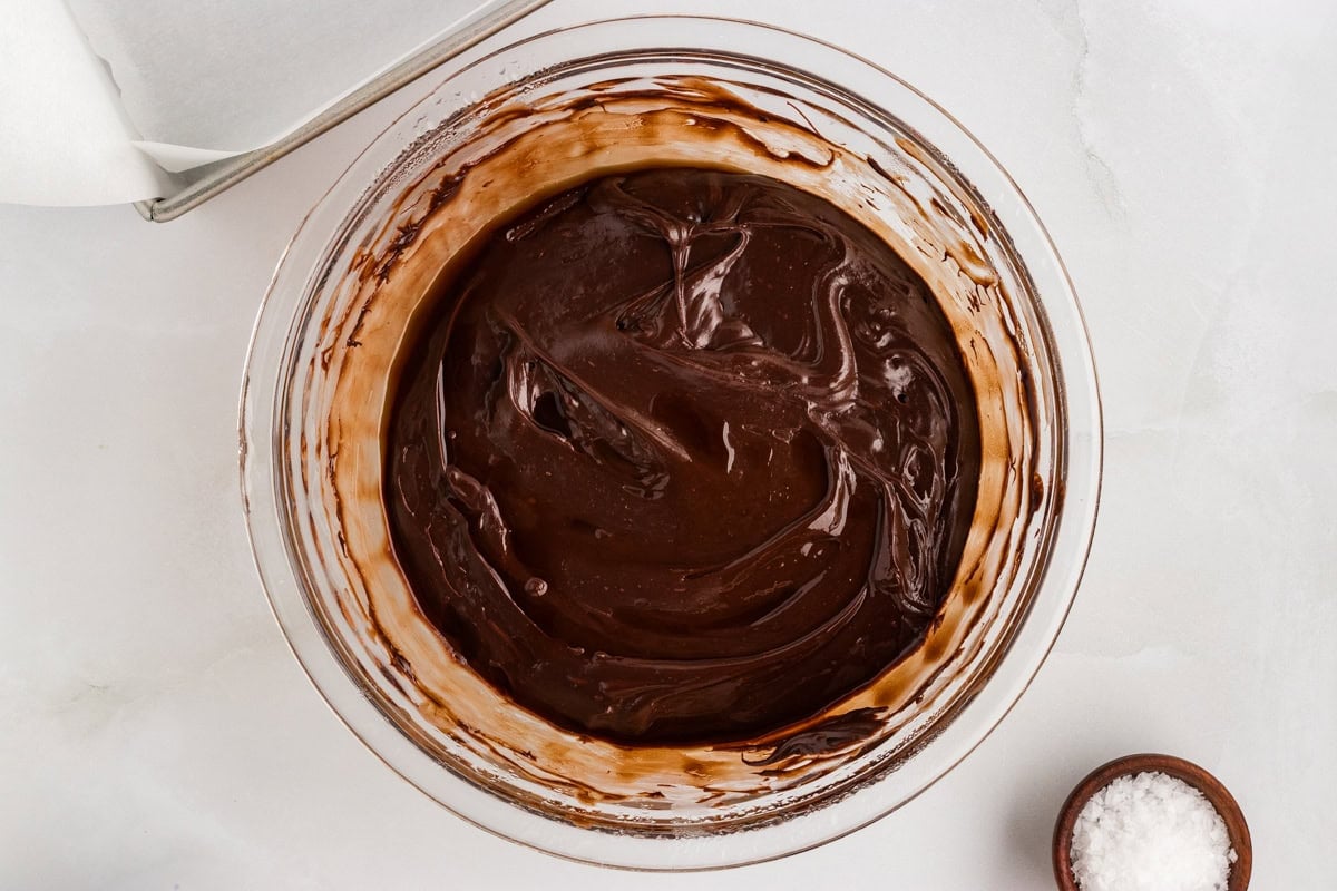 Overhead view of glossy, fully melted dairy-free chocolate fudge mixture in a glass bowl