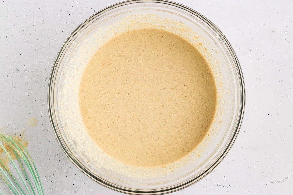 Smooth, thick oat flour pancake batter in a glass mixing bowl.