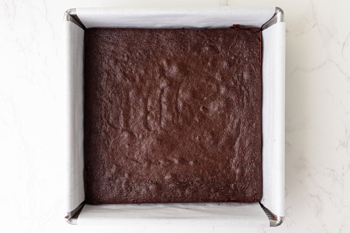 Baked gluten-free brownie in the pan, cooled and ready to be chilled before frosting.