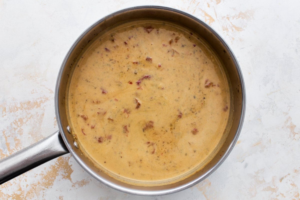 Creamy dairy-free Marry Me Chicken sauce simmering in a skillet until thickened, before the chicken is added back.