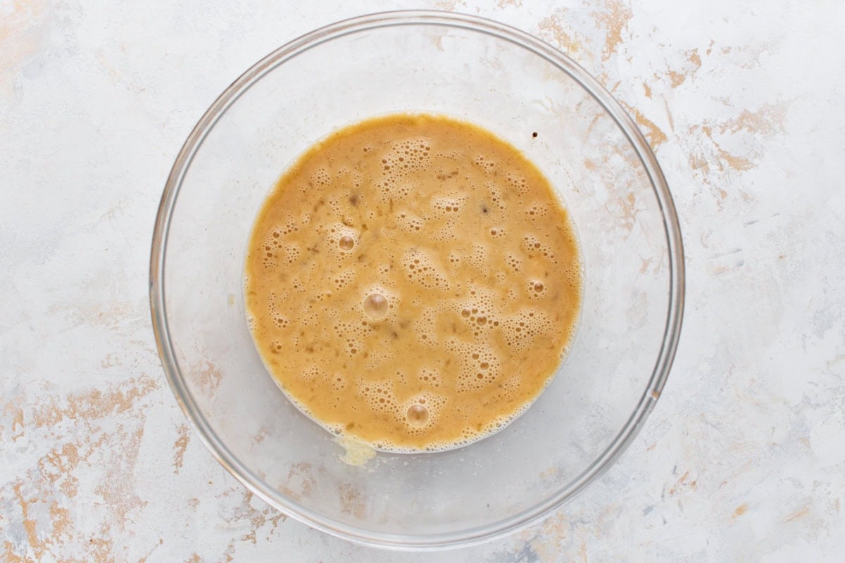 Whisked eggs, milk, and seasoning in a glass bowl, ready to scramble for gluten-free breakfast burritos